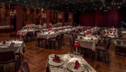 a group of tables in a room with red chairs at Algarve Casino Hotel in Portimão