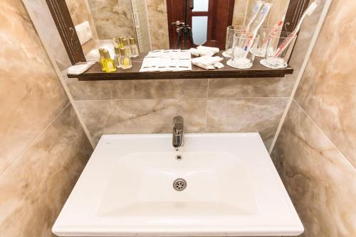 a bathroom with a white sink and a mirror at Hotel Baron in Odesa
