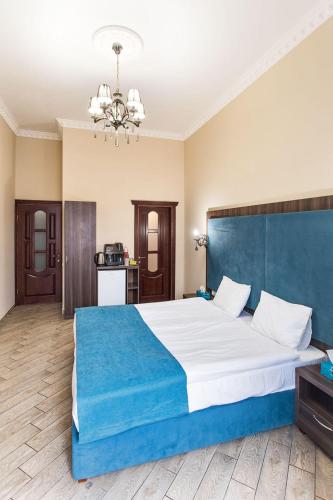 a bedroom with a large bed with a blue headboard at Hotel Baron in Odesa
