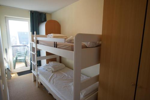 a room with three bunk beds and a window at Residentie Koksijde promenade in Koksijde