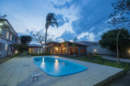 a swimming pool in the yard of a house at Ipê Hotel Express in Ponta Grossa