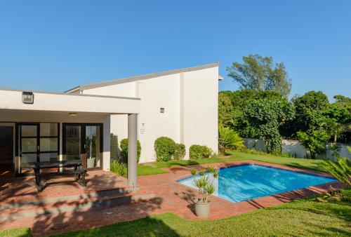 a house with a swimming pool in the yard at Sands Beach Breaks Umdloti Beach View in Umdloti
