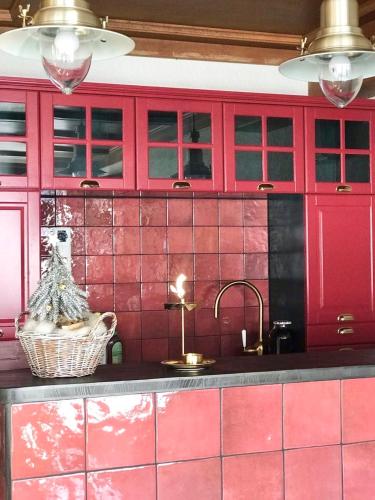 a kitchen with pink tiled walls and a sink at VILLA OXA - Boutique Design Hotel in Maria Alm am Steinernen Meer