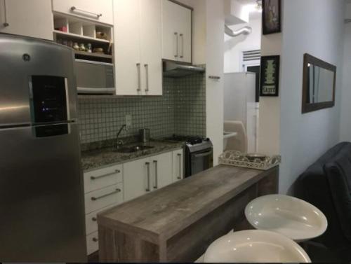 瓜魯雅的住宿－Lazer completo PRAIAS PISCINAS PLAYGROUND，厨房配有白色橱柜和木制台面