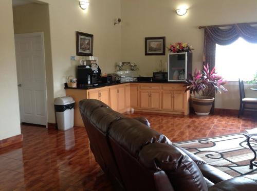 a living room with a couch and a kitchen at Scottish Inns & Suites Timber Creek, Houston, TX in Houston