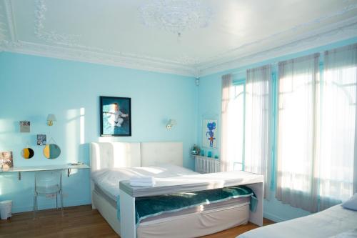 a blue bedroom with a bed and a desk at Villa Ananda Huo in Saint-Cloud