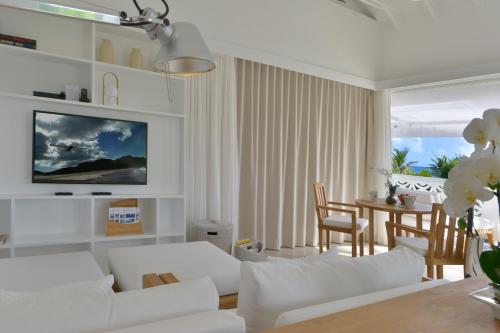 sala de estar con muebles blancos y mesa en Les Ilets De La Plage en Gustavia