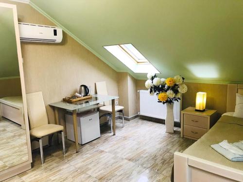 a room with a desk and a table with flowers at Hotel Aragvi in Mtskheta