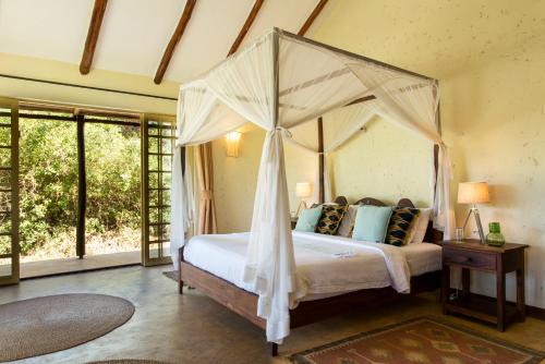 a bedroom with a bed with a canopy at Kili Villa Kilimanjaro Luxury Retreat in Arusha