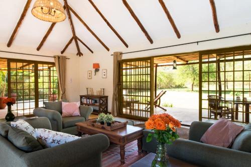 a living room with couches and a table at Kili Villa Kilimanjaro Luxury Retreat in Arusha