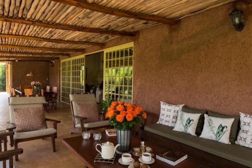a living room with a couch and flowers on a table at Kili Villa Kilimanjaro Luxury Retreat in Arusha