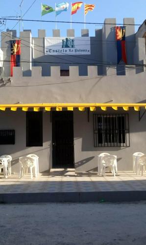 a group of white chairs sitting outside of a building at Hotel Castelo La Paloma in Gamboa