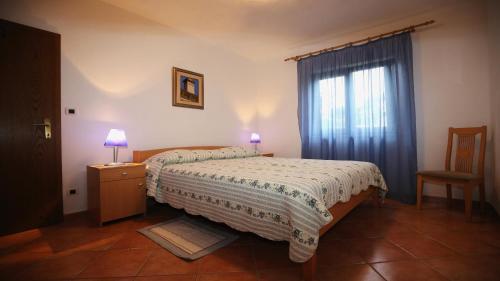 a small bedroom with a bed and a window at Bungalow Perla in Funtana