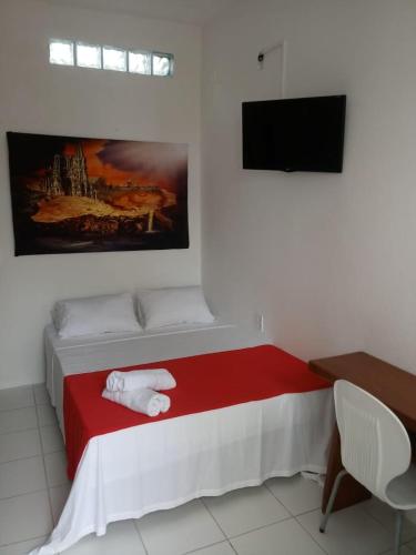 a bedroom with a red and white bed with a tv at Hotel Castelo La Paloma in Gamboa