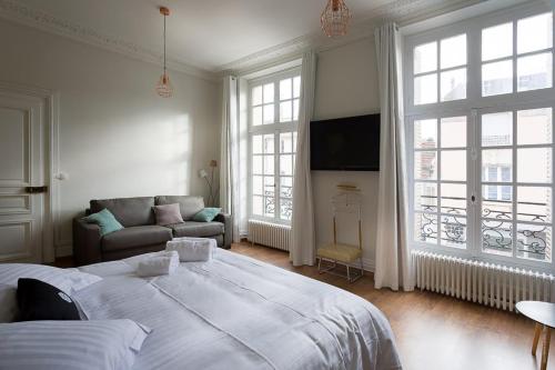 una camera da letto con un letto grande e un divano di Le Jardin d'Hiver a Chalons en Champagne