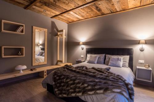 1 dormitorio con 1 cama grande y techo de madera en Ca' Dottori, en Albosaggia