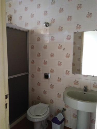 a bathroom with a toilet and a sink at Confortável 2 Quartos Castanheiras in Guarapari