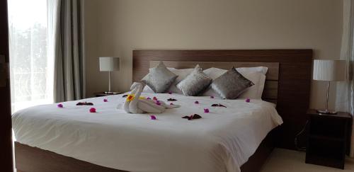 um quarto com uma cama branca com rosas em Northern Pearl Luxury Apartments em Mont Choisy