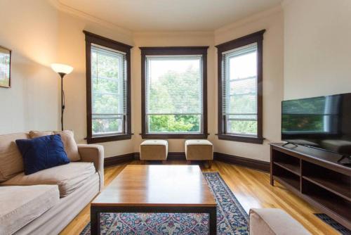 a living room with a couch and a tv at Wrigley Oasis! Steps from the Field! - 3BD 1BA in Chicago