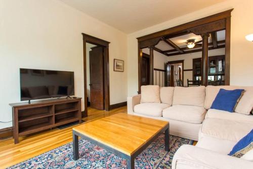 a living room with a white couch and a table at Wrigley Oasis! Steps from the Field! - 3BD 1BA in Chicago