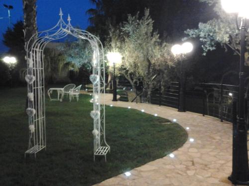 a garden with a wedding arch at night at Hotel Il Corsaro in Le Castella