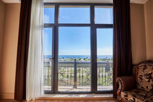 a window in a room with a view of the ocean at NOBEL Hotel in Baku