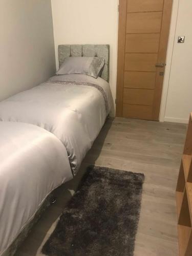 a bedroom with a bed and a rug and a door at The Bungalow in Leeds