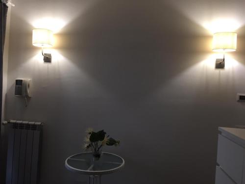 a bathroom with two lights on a wall with a table at Palese Profumo di Mare in Santo Spirito
