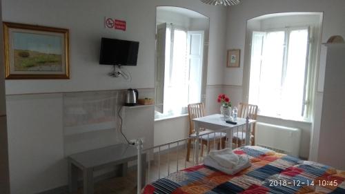 a bedroom with a bed and a table and window at Le rondini di San Donato in Lucca
