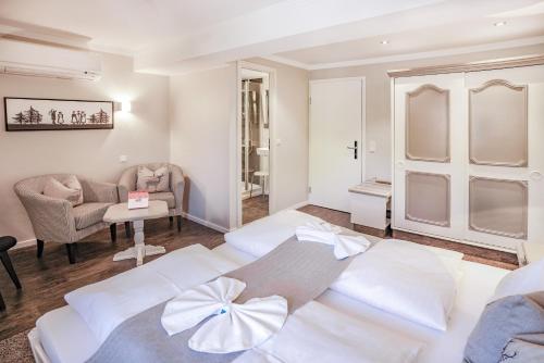 a bedroom with two white beds in a room at Hotel Restaurant Der Engel, Sasbachwalden in Sasbachwalden