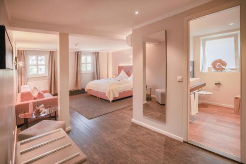 a bedroom with a bed and a living room at Hotel Restaurant Der Engel, Sasbachwalden in Sasbachwalden