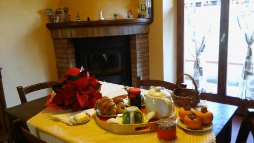 a table with a plate of food and a fireplace at Agriturismo il Bacucco in Montecarotto