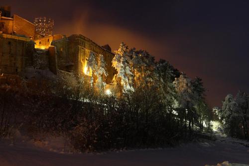 a building with lights on in the snow at night at Residenza La Torre in Santo Stefano di Sessanio