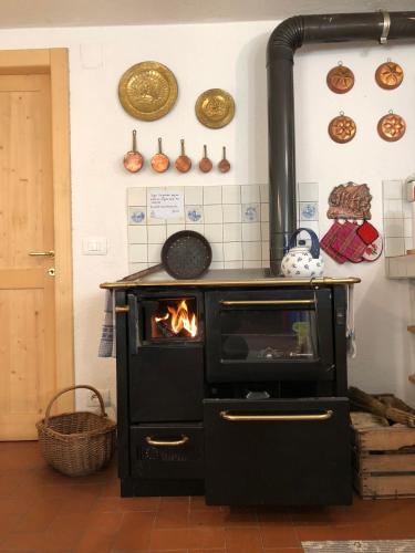 a stove with a fire in a room at Chalet Maso Pino in Castello Tesino