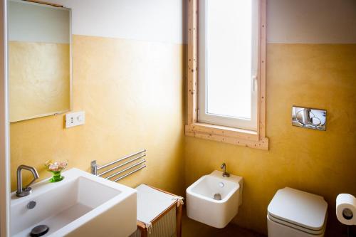 a bathroom with a sink and a toilet and a window at Casale Artemisia Capalbio in Capalbio