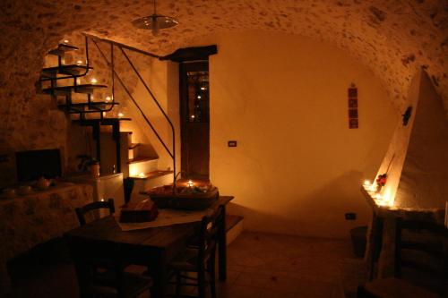 a room with a table and a staircase in a house at Residenza La Torre in Santo Stefano di Sessanio