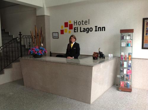 a woman sitting at a hotel elleeim counter at Hoteles Bogotá Inn El Lago Country Zona Rosa in Bogotá