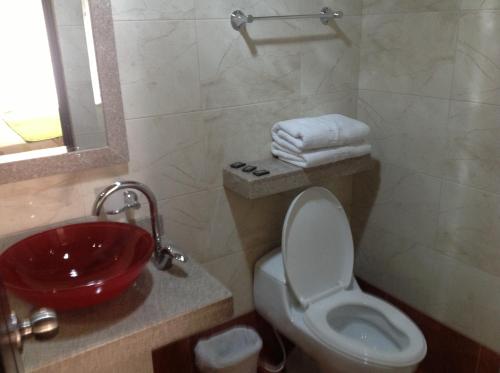 uma casa de banho com um lavatório vermelho e um WC. em Hoteles Bogotá Inn El Lago Country em Bogotá