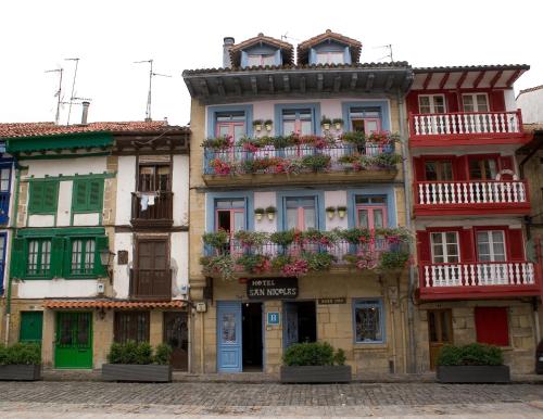 un edificio con cajas de flores en la parte delantera en Hotel San Nikolas, en Hondarribia