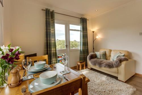 a living room with a table and a couch at Loch Broom Cabins Seaviews& Petfriendly in Leckmelm