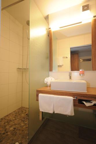a bathroom with a sink and a mirror at Superior Hotel Nidwaldnerhof in Beckenried