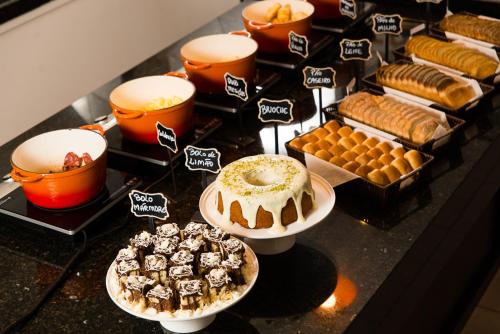 a bunch of desserts and pastries on a table at Hotel Campo Largo Express in Campo Largo