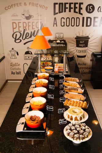 a buffet line with different types of food on at Hotel Campo Largo Express in Campo Largo