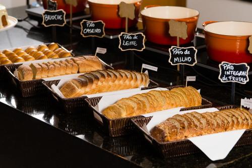 a display of bread and pastries in baskets on a counter at Hotel Campo Largo Express in Campo Largo