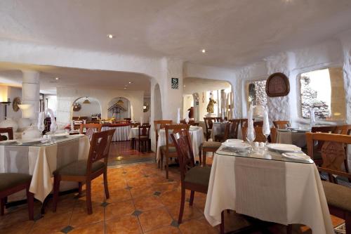 a restaurant with tables and chairs in a room at San Agustin Internacional in Cusco