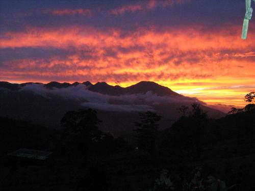 a sunset in the mountains with clouds in the sky at Celeste Mountain Lodge in Bijagua