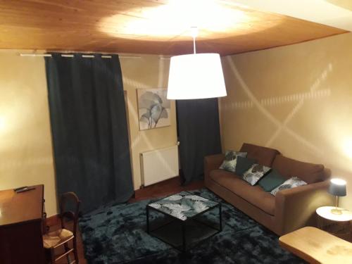 a living room with a couch and a table at Chambres d'hôtes Belle Occitane in Tarascon-sur-Ariège