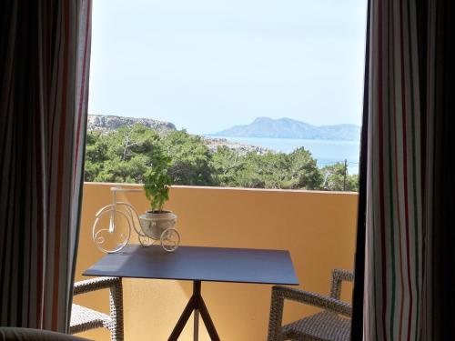 a table on a balcony with a view of the ocean at Miraluna Aparthotel in Lefkos Karpathou