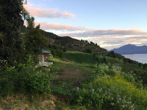 a house on a hill next to the water at Casa La Trafa in Futrono