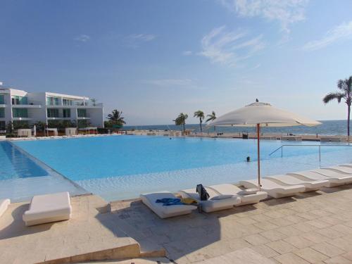 una gran piscina con tumbonas y sombrilla en ARIA OCEAN ACQUA NUEVO VALLARTA, en Nuevo Vallarta 
